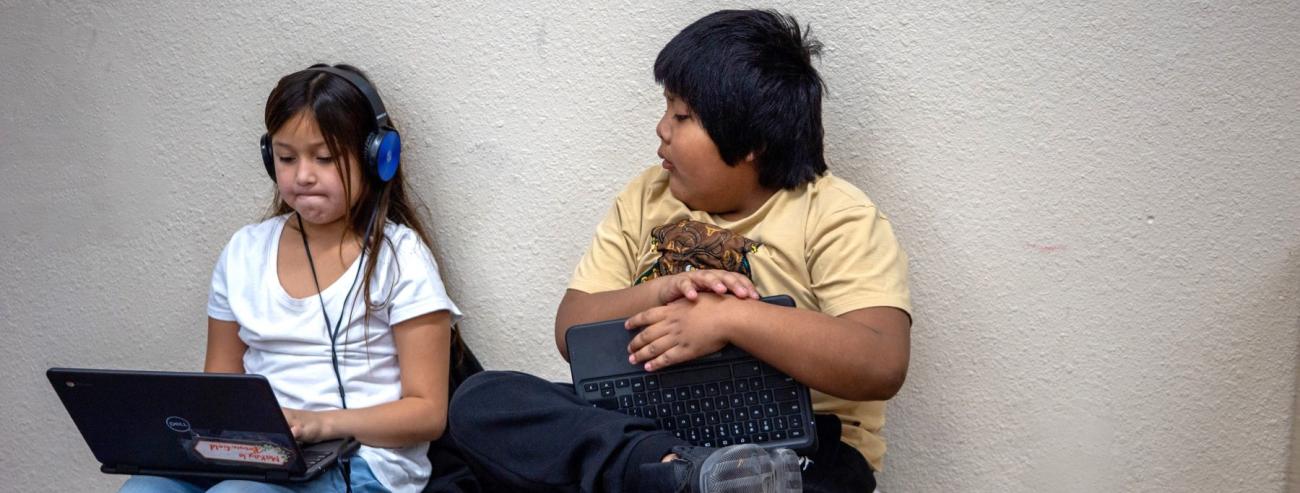 Two students working on laptop.